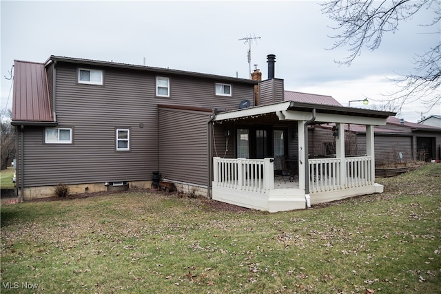 back of property with covered porch and a lawn