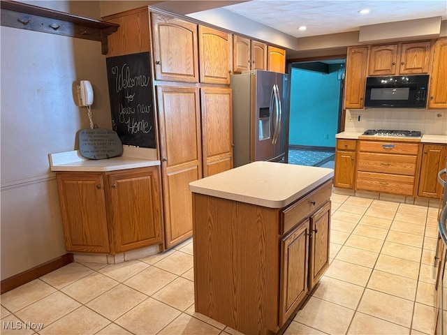 kitchen featuring backsplash, light tile patterned flooring, stainless steel appliances, and a kitchen island