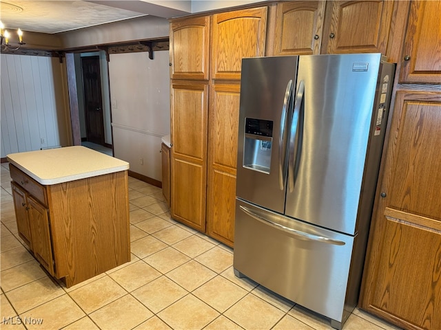 kitchen featuring stainless steel refrigerator with ice dispenser, a center island, and light tile patterned floors