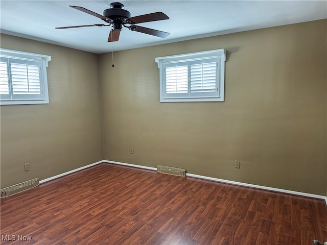 spare room with plenty of natural light, dark hardwood / wood-style floors, and ceiling fan