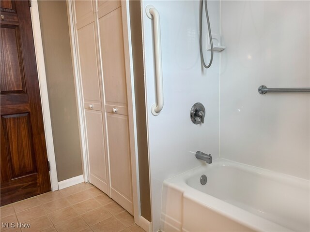 full bathroom with tile patterned floors,  shower combination, and baseboards