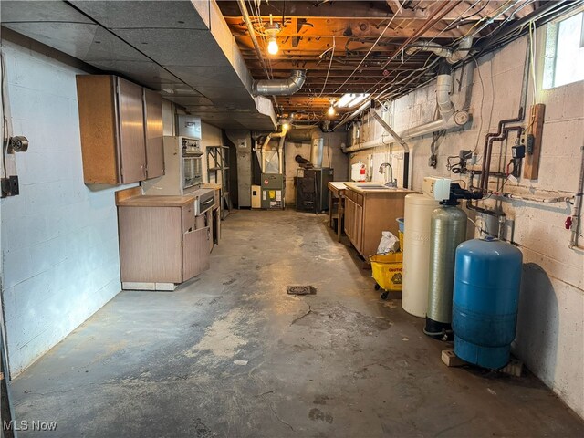 below grade area with heating unit and a sink