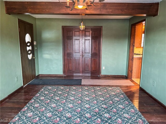 entryway with baseboards, beam ceiling, and hardwood / wood-style floors