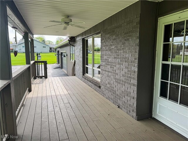 deck featuring ceiling fan and a yard