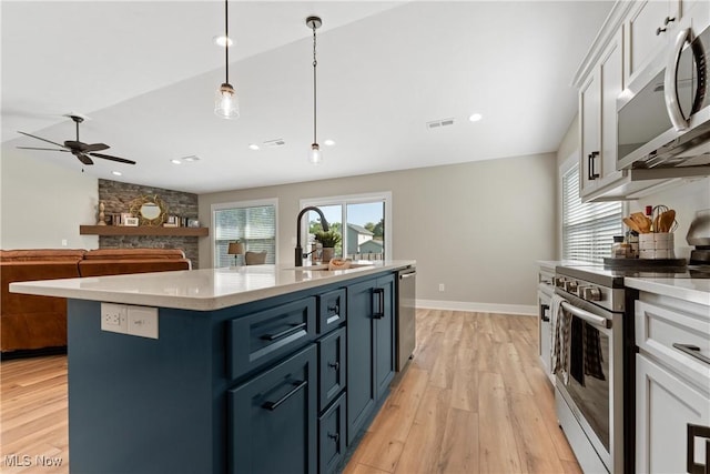 kitchen with white cabinets, decorative light fixtures, blue cabinets, and stainless steel appliances