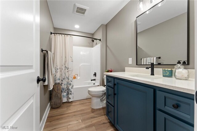 full bathroom with vanity, toilet, wood-type flooring, and shower / bath combo with shower curtain