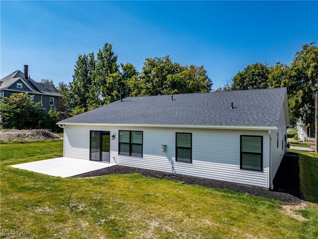 rear view of property featuring a patio and a lawn