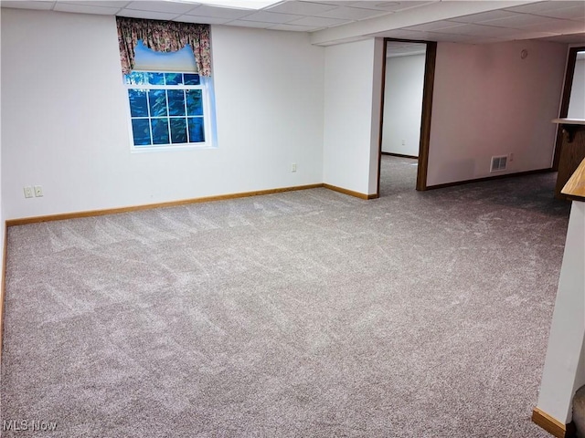 basement with a drop ceiling and carpet floors