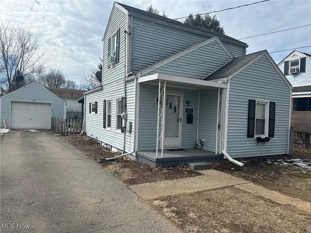 view of front of house featuring a garage, aphalt driveway, an outbuilding, and covered porch