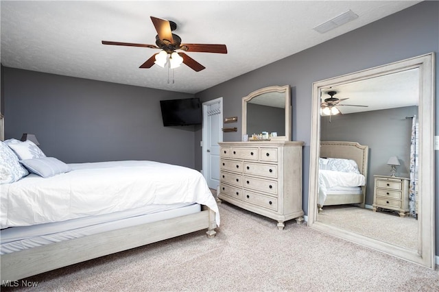 bedroom with carpet flooring, ceiling fan, and a textured ceiling