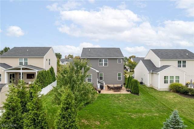 back of house with a yard and a patio