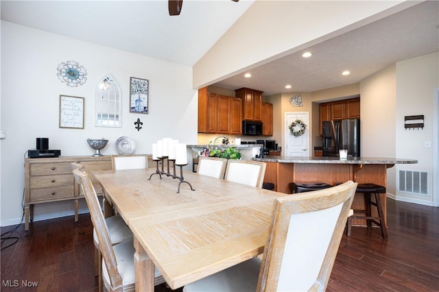 dining area with ceiling fan, dark hardwood / wood-style flooring, and vaulted ceiling