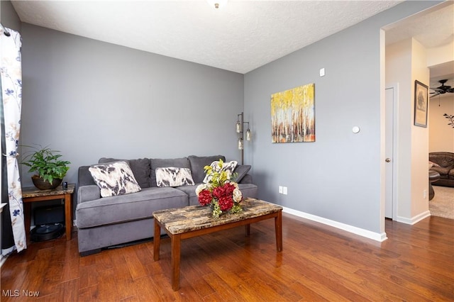 living room featuring ceiling fan and dark hardwood / wood-style flooring