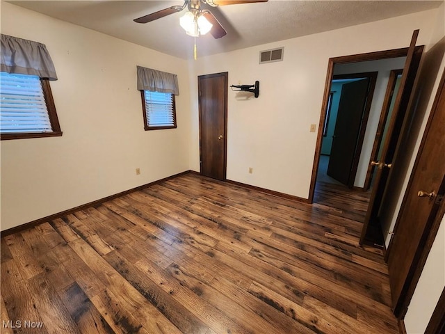 unfurnished bedroom with dark hardwood / wood-style flooring and ceiling fan