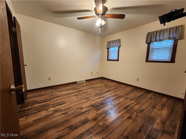 unfurnished room featuring dark hardwood / wood-style floors and ceiling fan