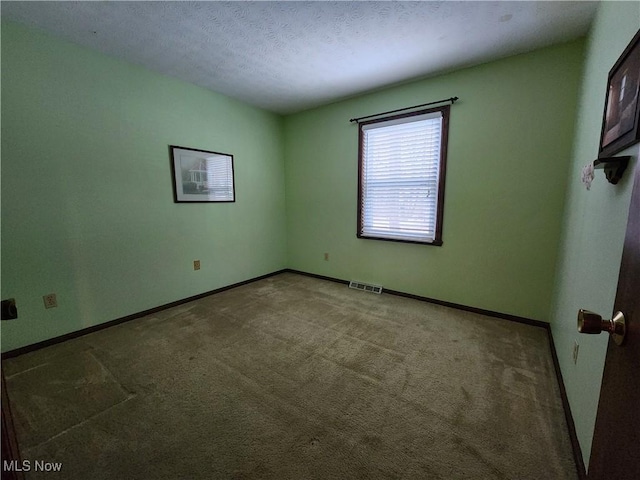 carpeted spare room with a textured ceiling