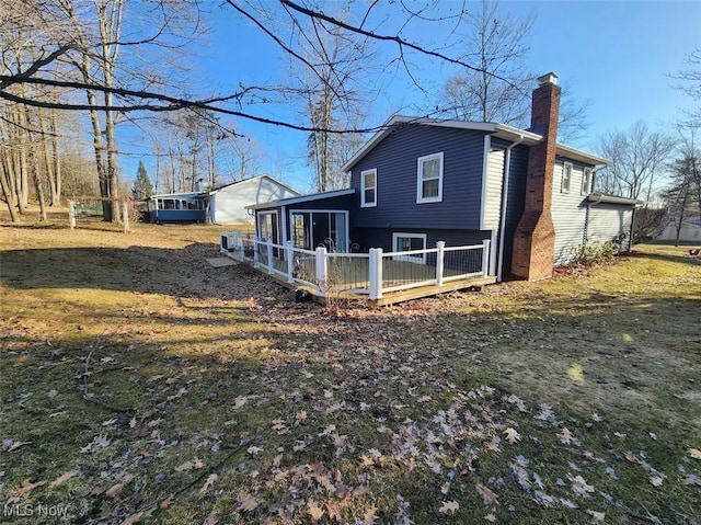 rear view of house featuring a chimney and a sunroom