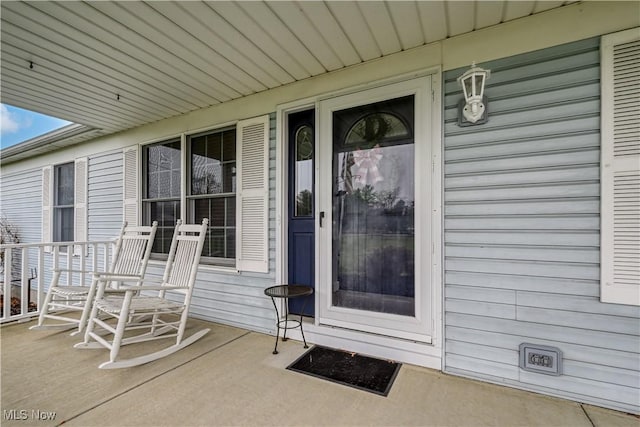 view of exterior entry featuring covered porch