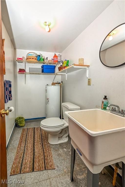 bathroom with toilet, sink, and water heater