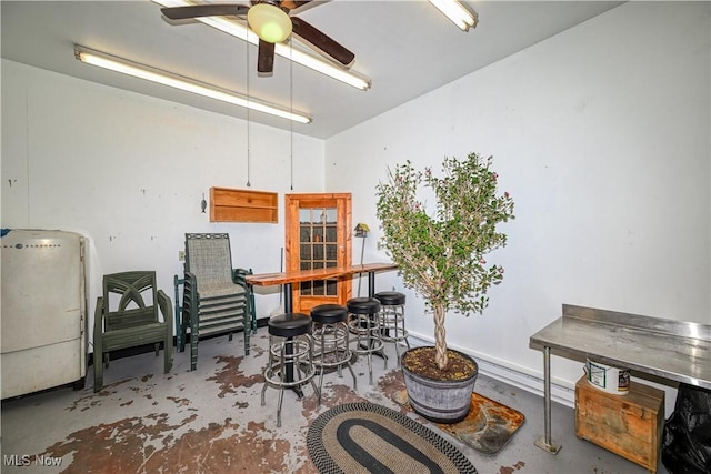 miscellaneous room with ceiling fan and concrete flooring