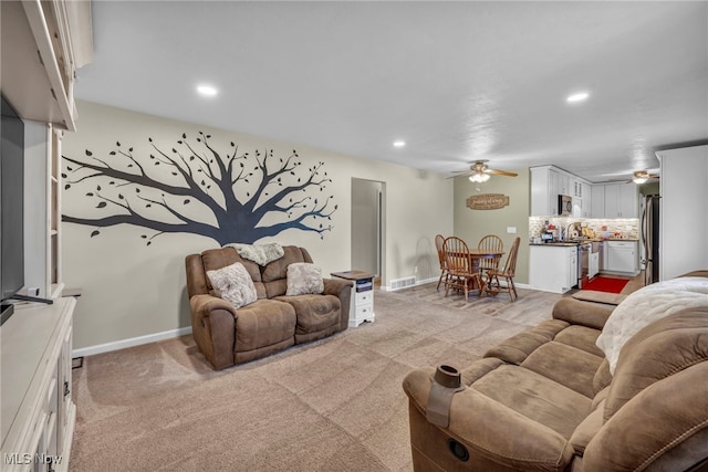 carpeted living room featuring ceiling fan