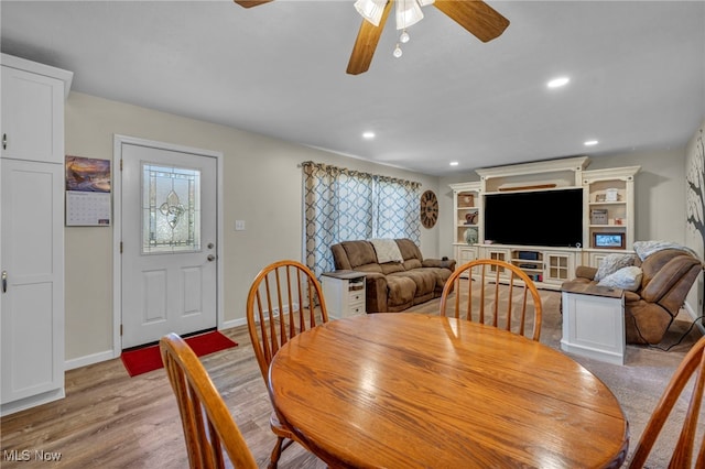 dining space with ceiling fan and light wood-type flooring