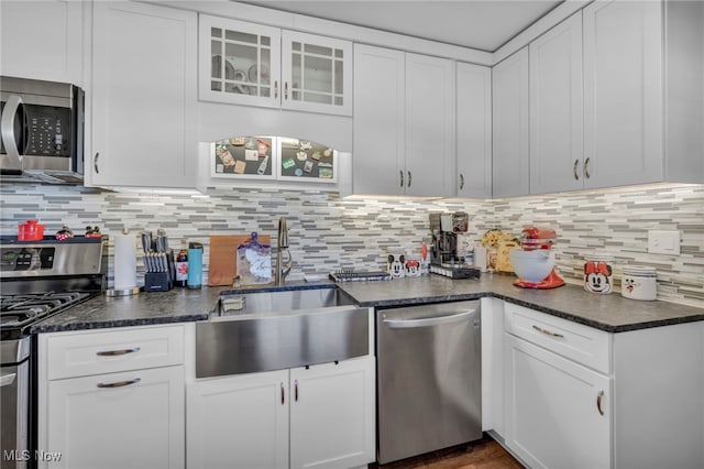 kitchen with backsplash, white cabinets, and appliances with stainless steel finishes