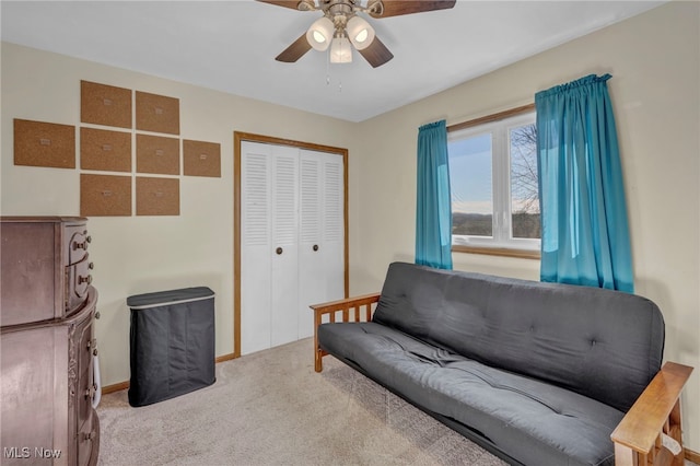 living area with ceiling fan and light colored carpet