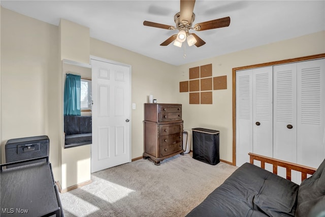 carpeted bedroom featuring ceiling fan and a closet