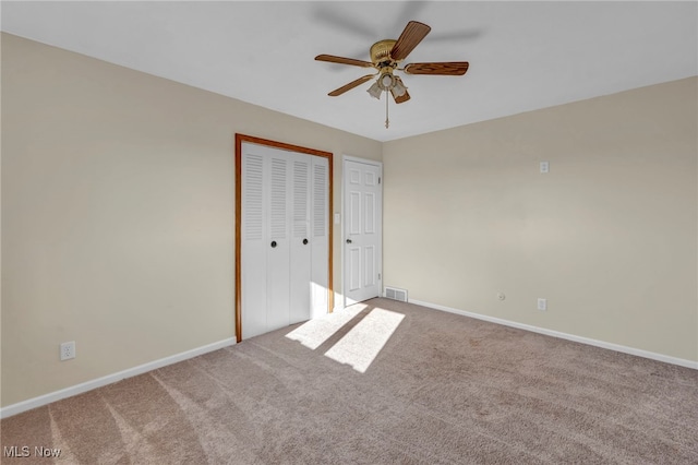 unfurnished bedroom featuring carpet flooring, ceiling fan, and a closet