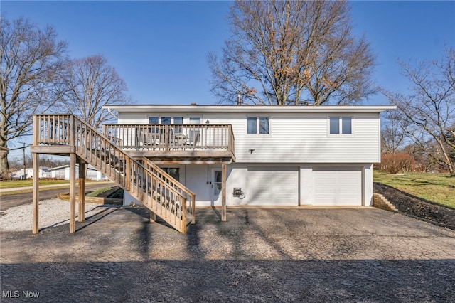 back of property with a garage and a wooden deck