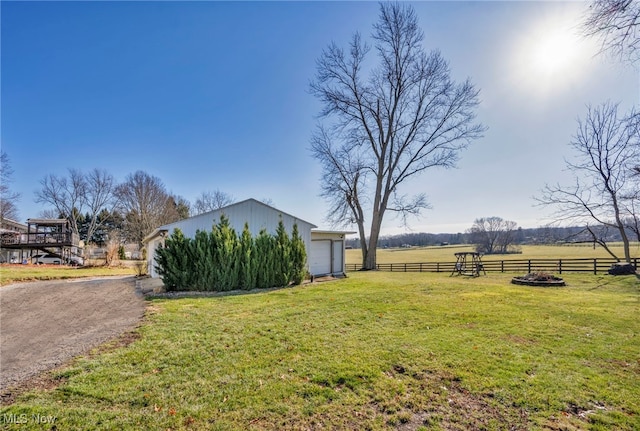 view of yard with an outbuilding, a rural view, and a garage