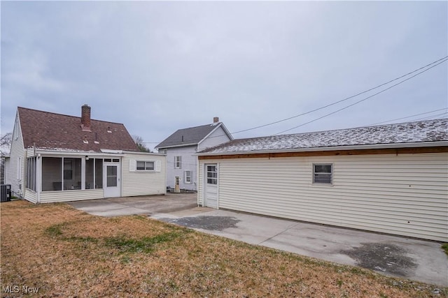 rear view of house featuring a yard, cooling unit, a patio area, and a sunroom