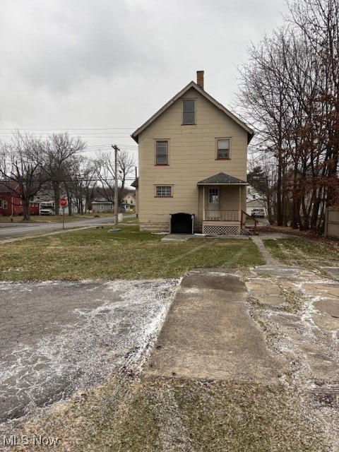 rear view of house with a porch and a yard