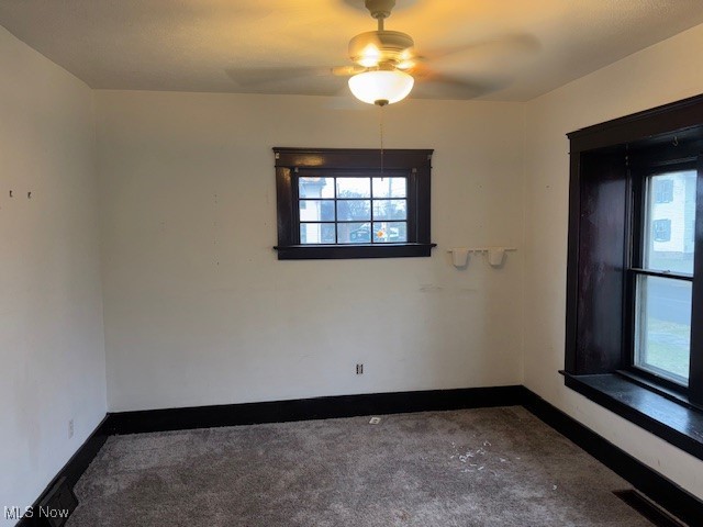 carpeted spare room featuring ceiling fan