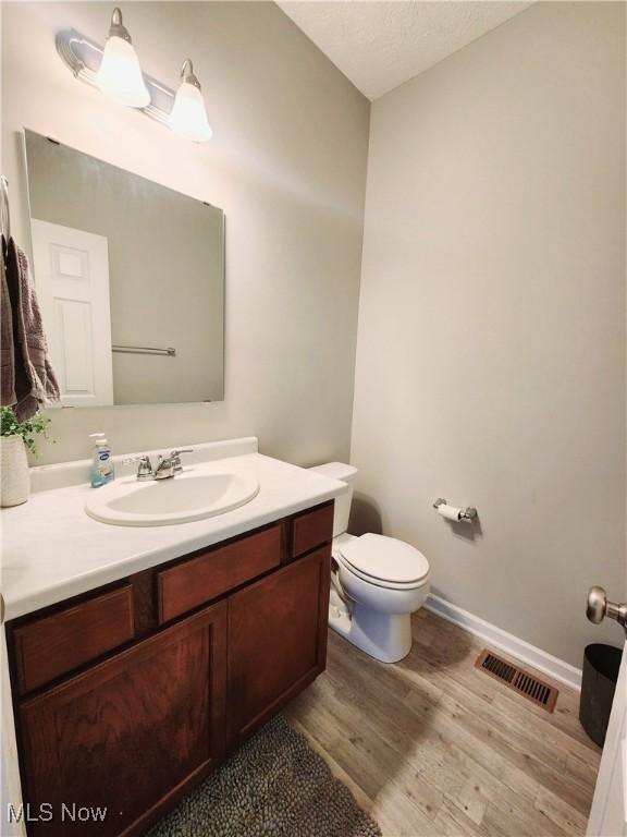 bathroom featuring hardwood / wood-style flooring, vanity, and toilet