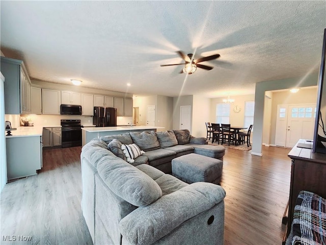 living room with hardwood / wood-style floors, sink, a textured ceiling, and ceiling fan