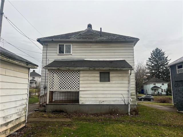 rear view of property with a lawn