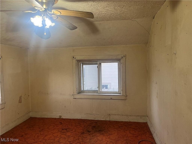 spare room with carpet flooring, ceiling fan, and vaulted ceiling