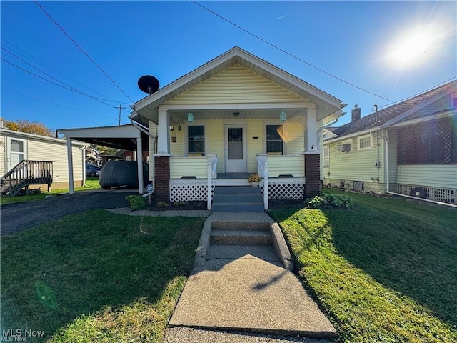 bungalow with a front yard, a porch, and a carport