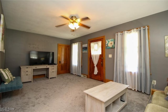 living room featuring light colored carpet, a wealth of natural light, and ceiling fan