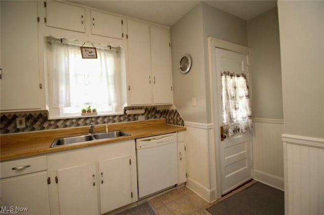 kitchen with backsplash, dishwasher, white cabinetry, and sink