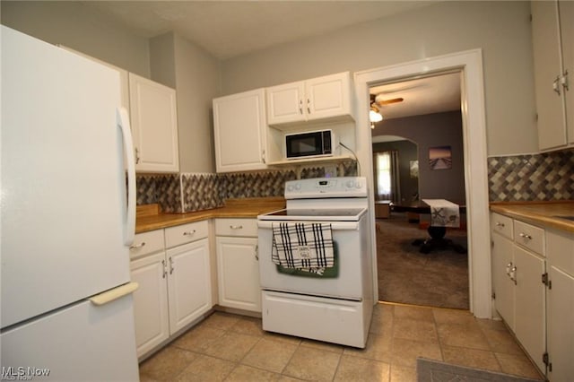 kitchen featuring white cabinetry, ceiling fan, backsplash, white appliances, and light carpet