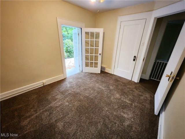 carpeted spare room featuring french doors