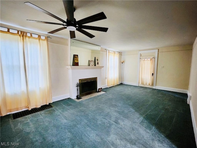 unfurnished living room with dark carpet and ceiling fan