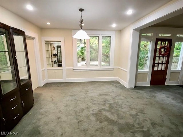 unfurnished dining area featuring dark carpet