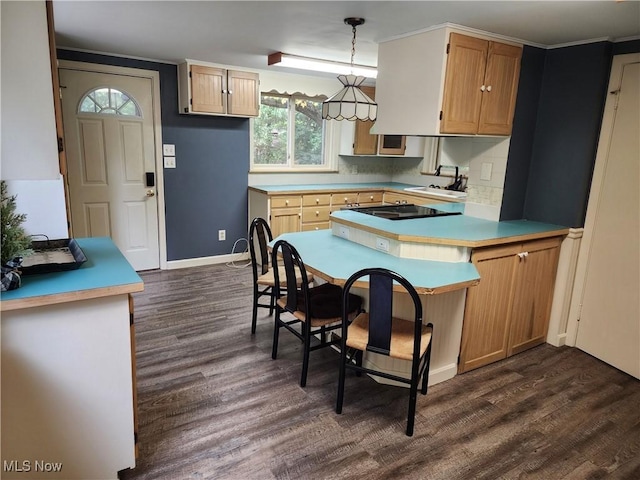 kitchen with dark wood-type flooring, hanging light fixtures, tasteful backsplash, kitchen peninsula, and black electric cooktop