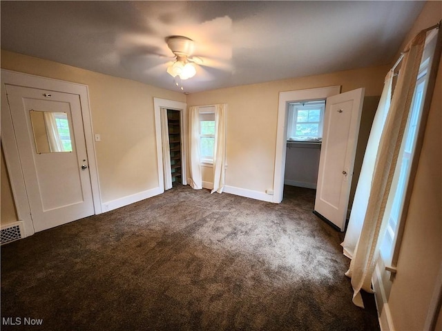 unfurnished bedroom featuring ceiling fan and dark colored carpet