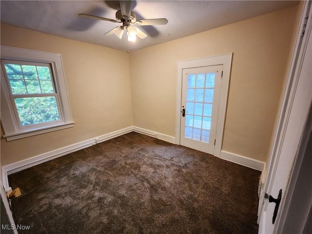 empty room with dark carpet and ceiling fan