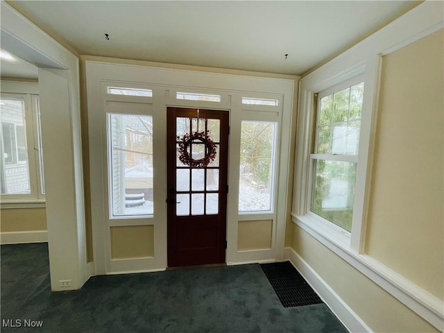 entryway with dark colored carpet